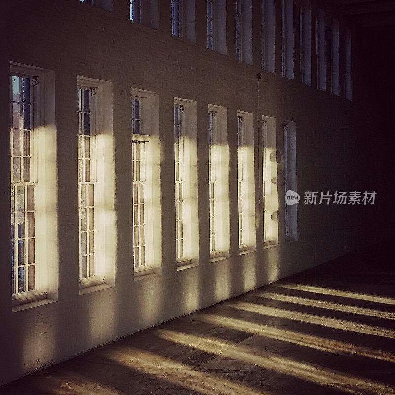 Evening Light Shining Through Row of Tall Windows